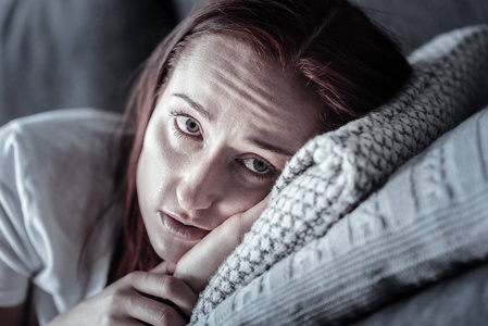 忧郁的不快乐的女人在枕头上哭泣照片