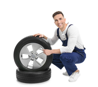 男性技工与汽车轮胎在白色背景