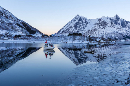 冬季景观与小船在平静的峡湾, 雪山和重新