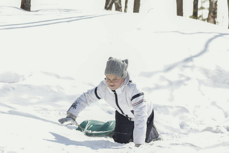 小女孩少年在冬天阳光明媚的森林与雪橇