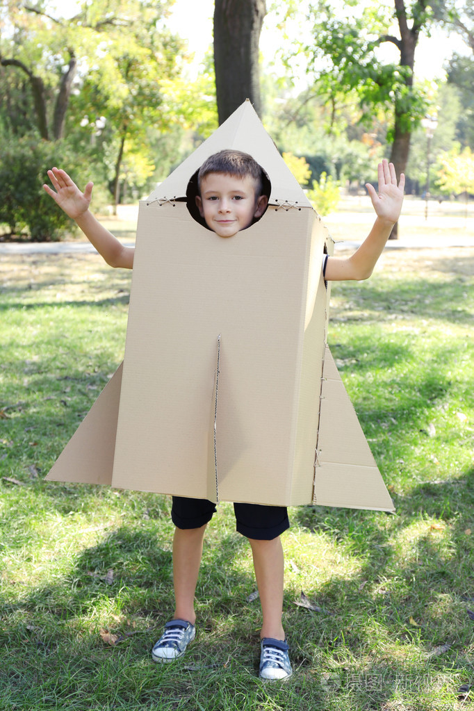 滑稽的男孩在纸箱头盔