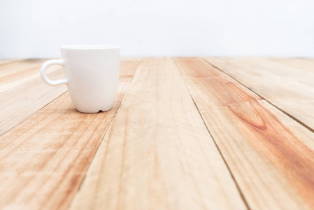 白色的木桌上的杯子和水泥的背景墙上，软焦点
