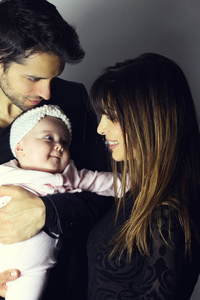 女人和男人抱着一个新生儿。妈妈, 爸爸和宝宝微笑着