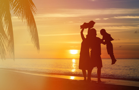 幸福的家庭，与日落海滩上玩耍的两个孩子