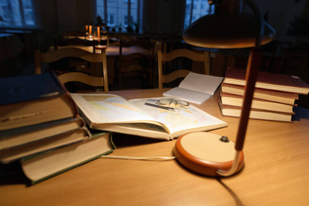 上一张桌子一盏台灯和图书馆的书