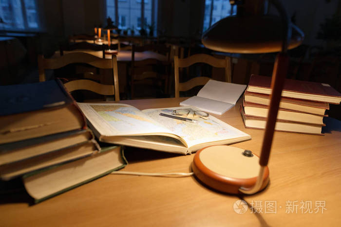 上一张桌子一盏台灯和图书馆的书