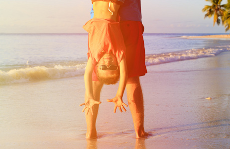 父亲和快乐的小儿子在沙滩上玩