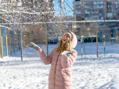 幸福的年轻女人玩户外的雪。冬季的一天。幸福的家庭。积极的人类情感，感情，快乐。积极冬季游戏