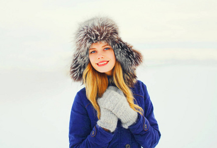 冬季时尚肖像幸福微笑的女人穿着毛皮帽子 ov