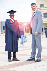 两名男生在毕业典礼上互相祝贺的镜头
