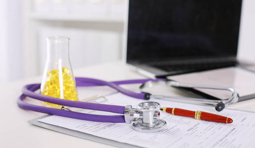 医生办公室带着听诊器在前景和背景中丸一瓶桌子的特写