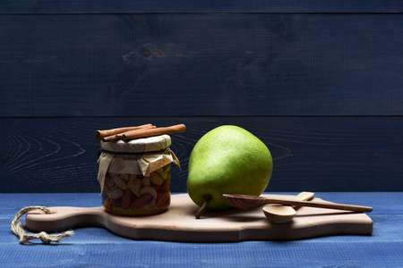 梨，坚果的玻璃罐在菜板上