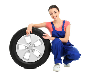 女性技工在白色背景的制服与汽车轮胎