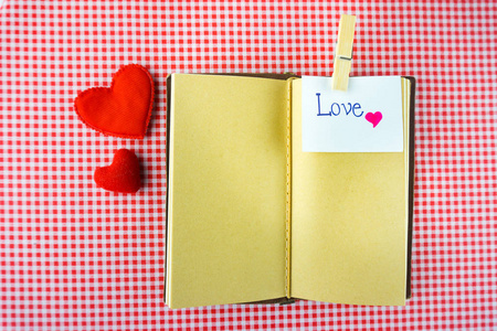 情人节礼物笔记本与留言卡上的红色背景的图像