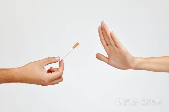 美丽的女人手拿香烟所拒绝的特写