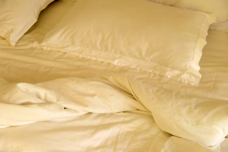 起床后凌乱的床上皱巴巴的毯子的顶部视图