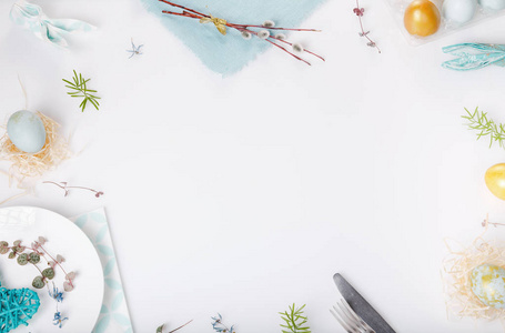 复活节餐桌设置与黄金和蓝色的鸡蛋和餐具.假期背景照片