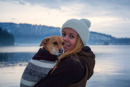 belc年轻女子抱着她的小狗, 吉娃娃, 在她的怀里, 在一个充满活力的