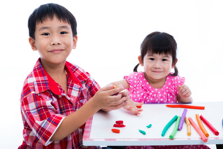 亚洲小孩玩玩黏土在桌子上。加强孩子的想象力