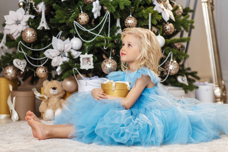 小金发女孩与礼物在圣诞树附近