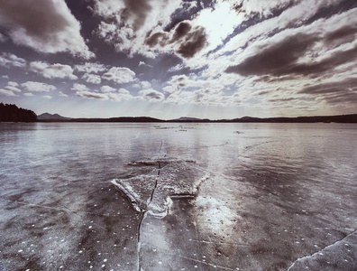冰浮冰在结冰的湖表面与反射。深裂纹