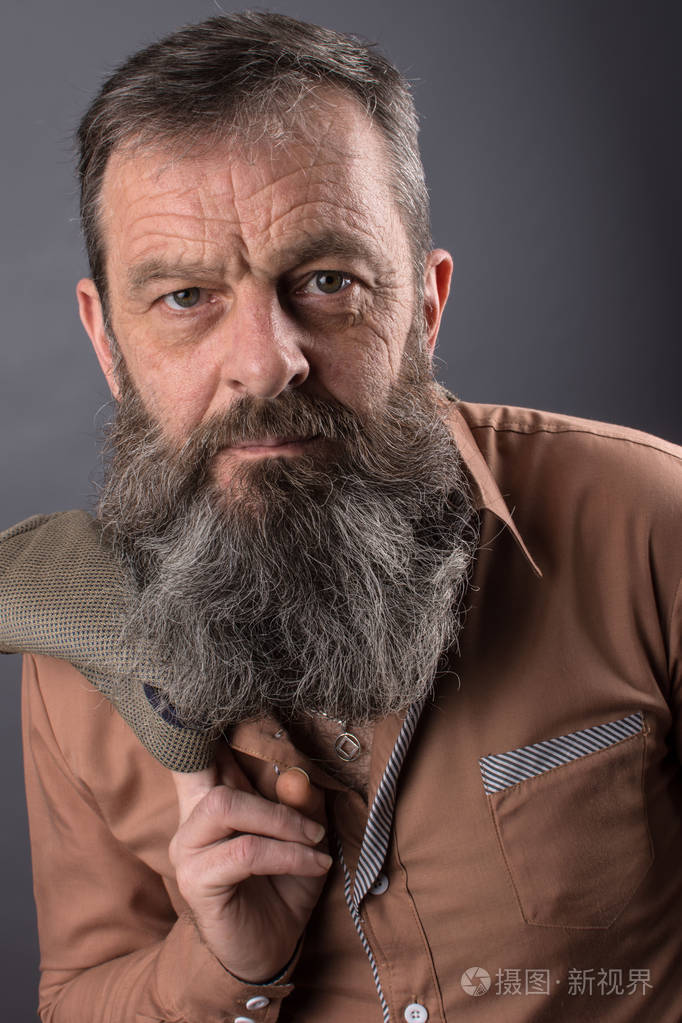 照片的愤怒的坏脾气老人看起来非常不满男满长长的胡须他的脸上关闭了
