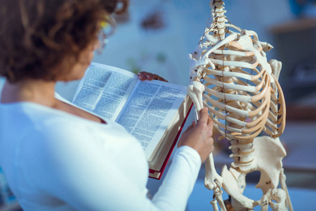 医生女人使用人体骨架模型的解剖学教学