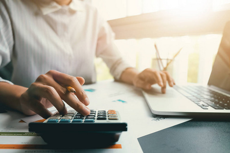 水仙花过滤效果关闭的妇女或会计手拿着铅笔工作计算器计算业务数据