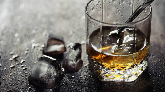 威士忌加冰块和玻璃杯木桌上的冰块
