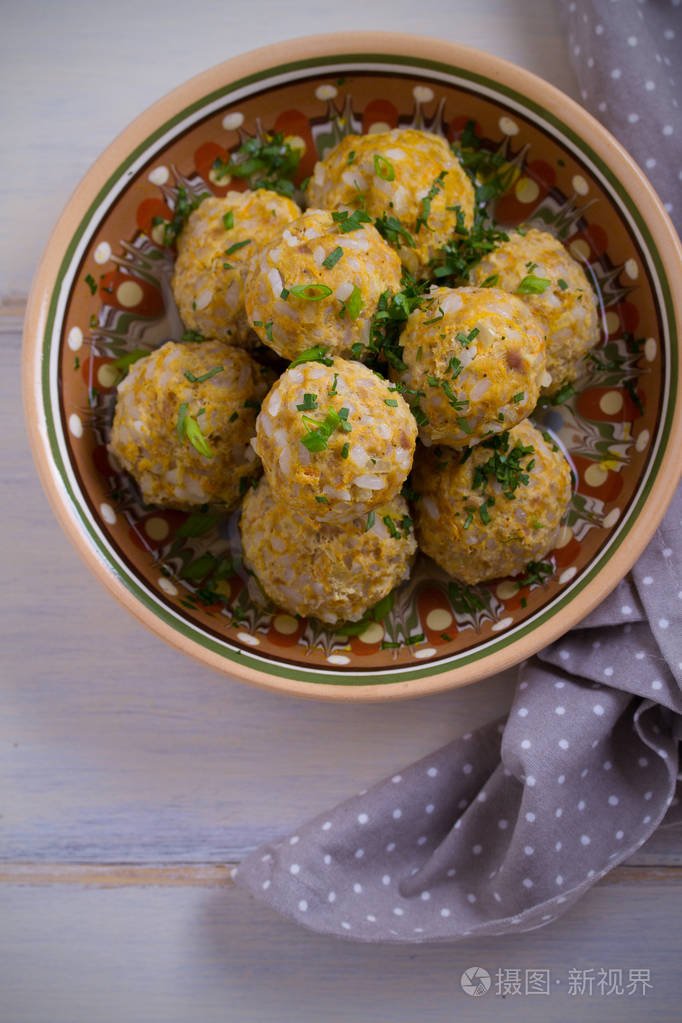 白木桌上有米饭和蔬菜的肉丸碗