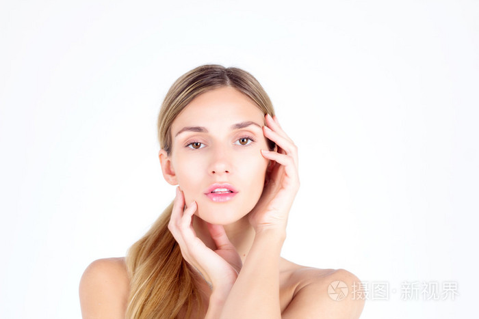 光洁的皮肤.美丽的女人用她的手看着相机和动人的脸