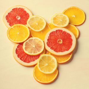 柑橘类水果的心从白色背景上的葡萄柚 柠檬 橙片。爱，健康，生态概念