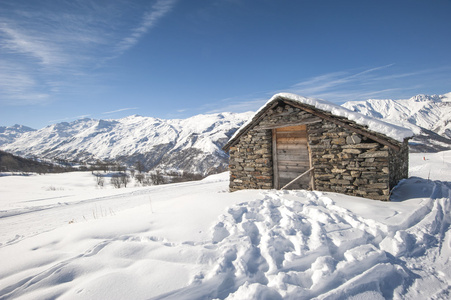 在雪中的孤立的山间小屋图片