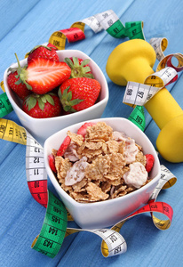 新鲜的草莓 小麦和黑麦片 哑铃和厘米，健康和运动的生活方式