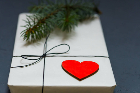 用花边绑在一起的工艺纸的礼品盒。一颗木红色的心