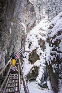 年轻女子徒步穿越雪山峡谷 Baerenschuetzklamm 与 f