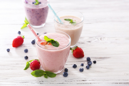 新鲜的草莓 蓝莓和牛奶酸奶有薄荷和周围轻木背景上的浆果