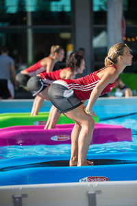 女生在室外泳池中练习漂浮健身垫