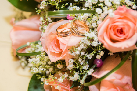 两个结婚戒指上一束粉色玫瑰
