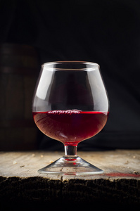 玻璃白葡萄酒和串葡萄在木制的背景