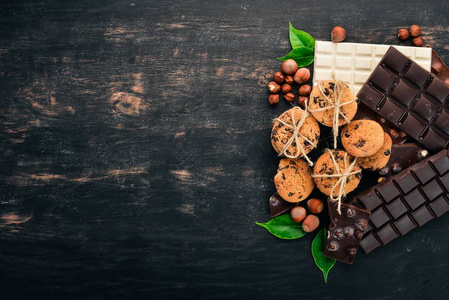 燕麦饼干和巧克力汤和糖果。在黑色的木质背景。顶部视图。复制文本空间