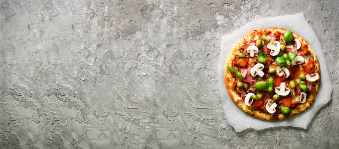 新鲜意大利比萨与蘑菇, 火腿, 蕃茄, 乳酪, 橄榄, 罗勒在灰色具体背景。复制空间。自制的爱。交货快。食谱和菜单。旗帜