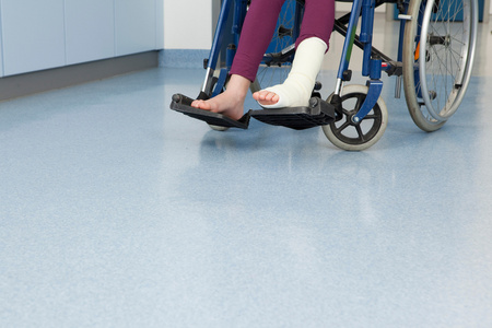 绑丝脚轮椅上的女孩的脚绑着绷带照片