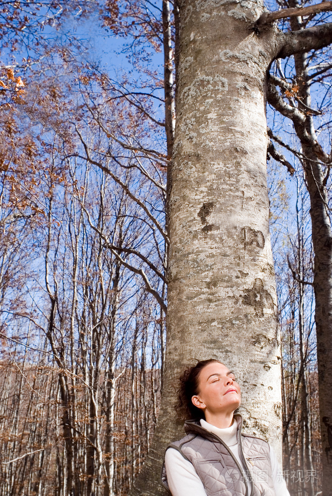 女人靠在树上微笑