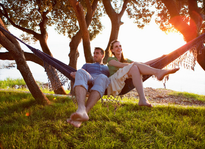 一对夫妇躺在海滩的吊床上照片