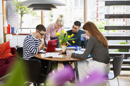外国人学习交流四个年轻人围坐在桌子旁学习照片