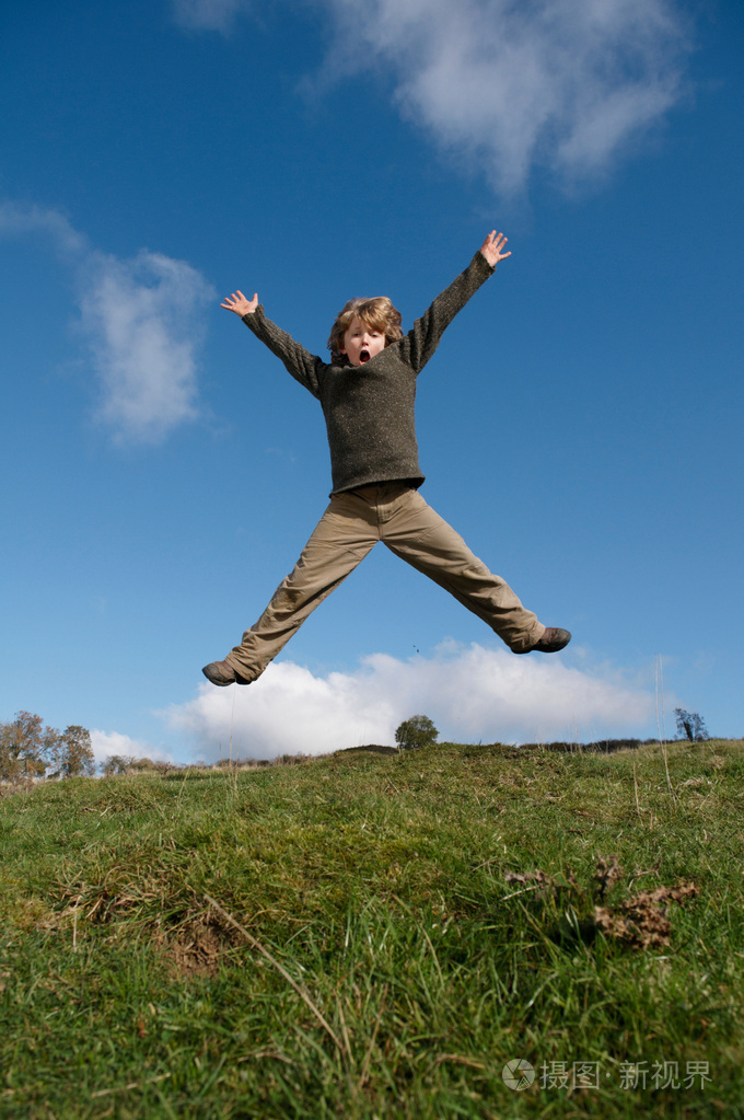 男孩在山上跳跃