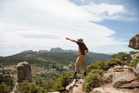 悬崖上的男人指向远方照片