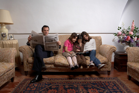 男人在沙发上看报父子在家里一起看报纸印度人喝咖啡,看报纸爸爸和