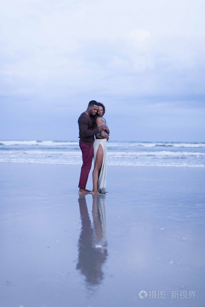 一对夫妇站在海滩上拥抱